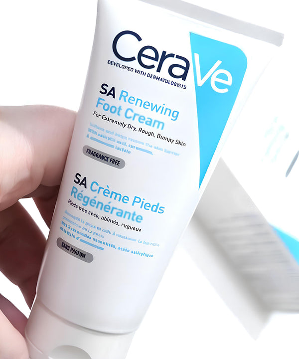 CeraVe SA Renewing Foot Cream tube held by a hand on a white background