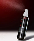 Black spray bottle with white nozzle on a dark background