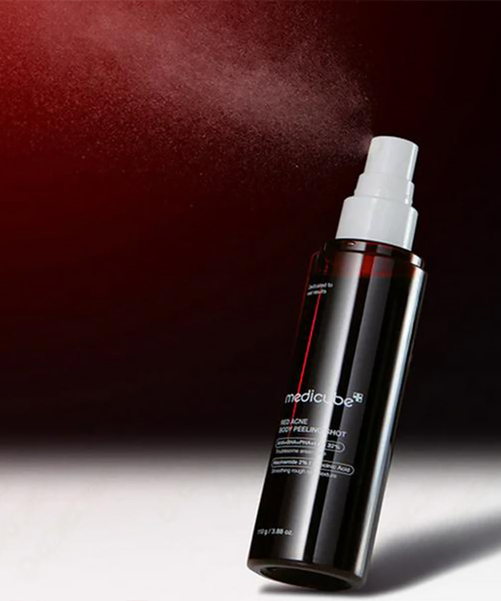 Black spray bottle with white nozzle on a dark background