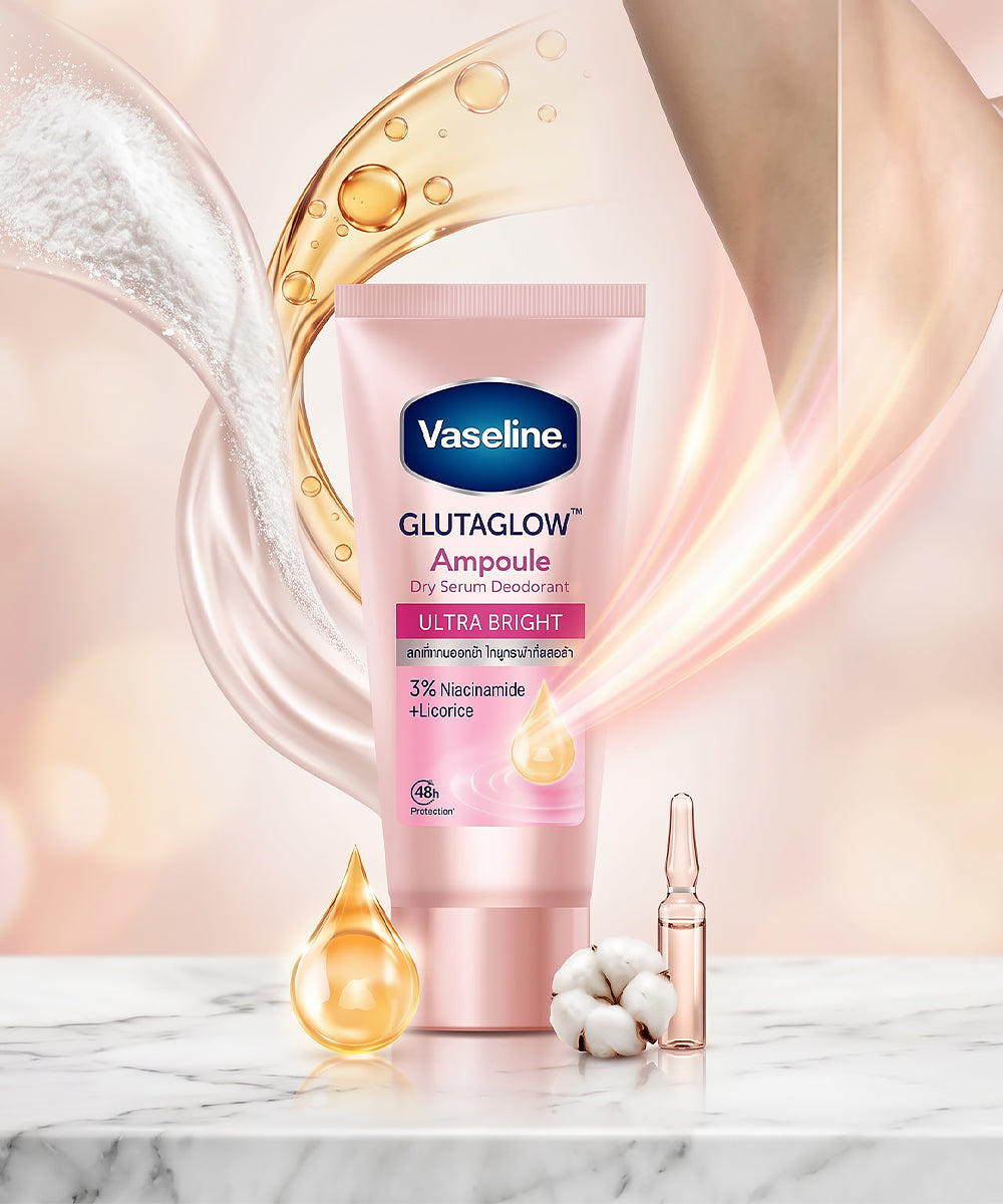 Vaseline Glutaglow Ampoule dry serum deodorant tube in pink packaging, displayed on a marble surface with decorative golden liquid swirls, a droplet, cotton bolls, and an ampoule vial.