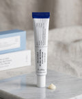 A hand holding the Dr. Althea Pure Retinol 0.15% Cream tube, showcasing the sleek, minimalist design and compact, travel-friendly size