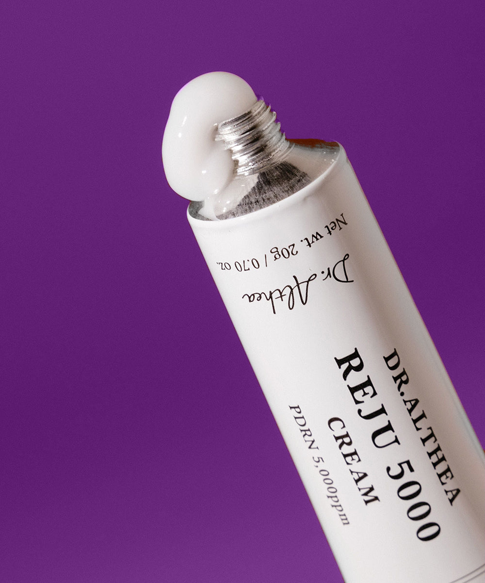 Dr. Althea Reju 5000 cream tube with a white cap on a purple background
