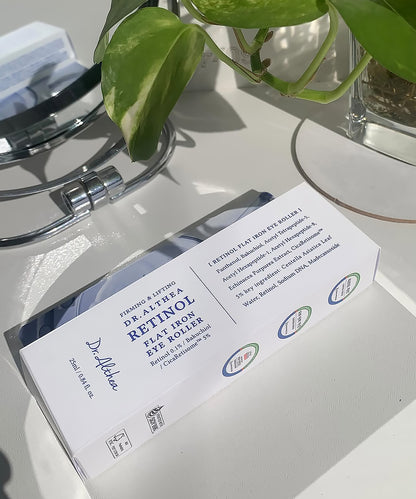 The outer product packaging for the Dr. Althea Retinol Eye Roller, showcasing the professional box design and ingredient list alongside a decorative indoor plant