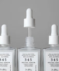 Three clear glass dropper bottles of Dr. Althea 345 Relief Serum arranged symmetrically against a neutral gray background.