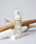 Skincare serum bottle with text on a light gray background