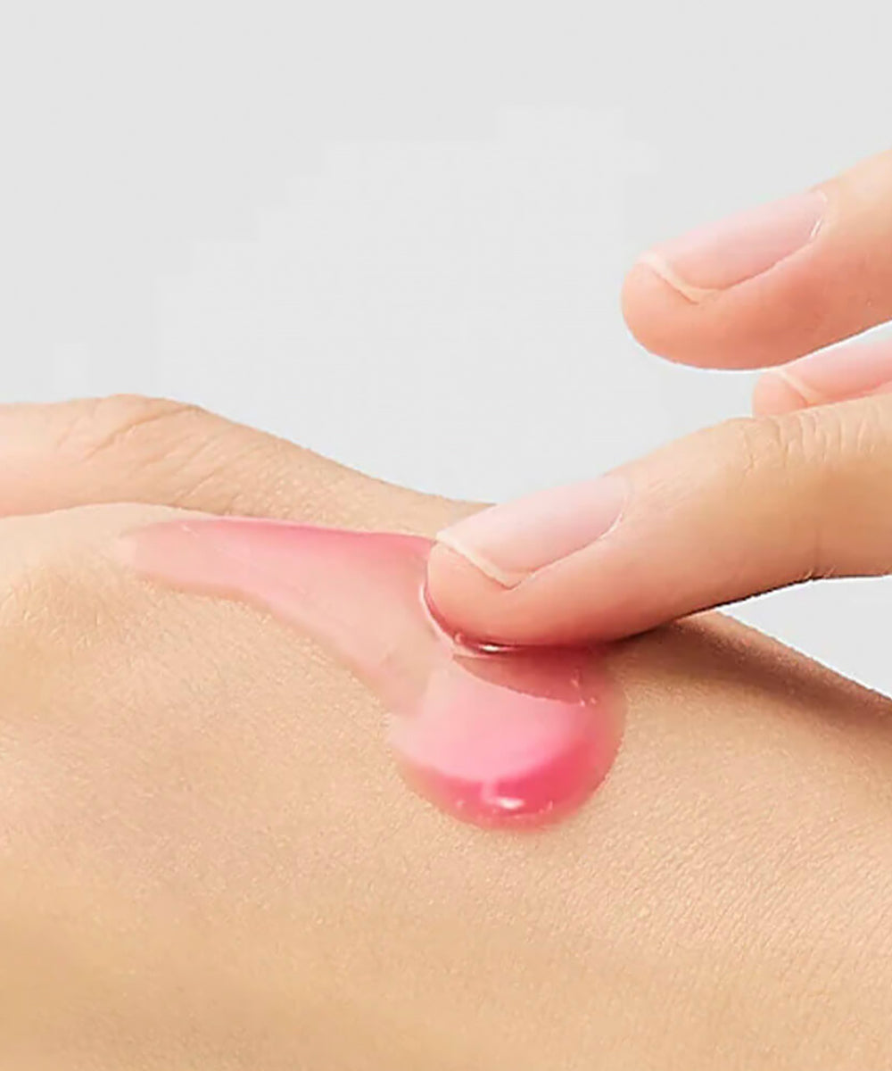 A close-up texture shot showcasing a dollop of the Dr. Melaxin Calcium B12 Spicule Cream, highlighting its smooth, pale pink consistency