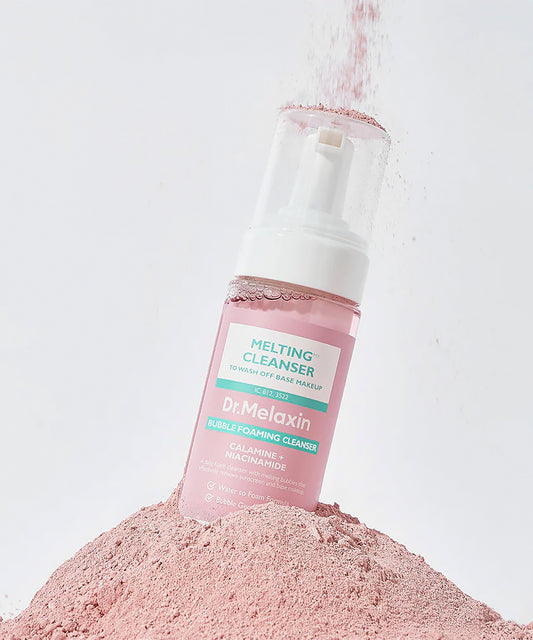 Dr. Melaxin Melting Cleanser bottle on a pile of pink powder against a light gray background