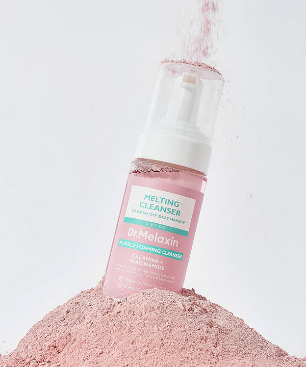 Dr. Melaxin Melting Cleanser bottle on a pile of pink powder against a light gray background