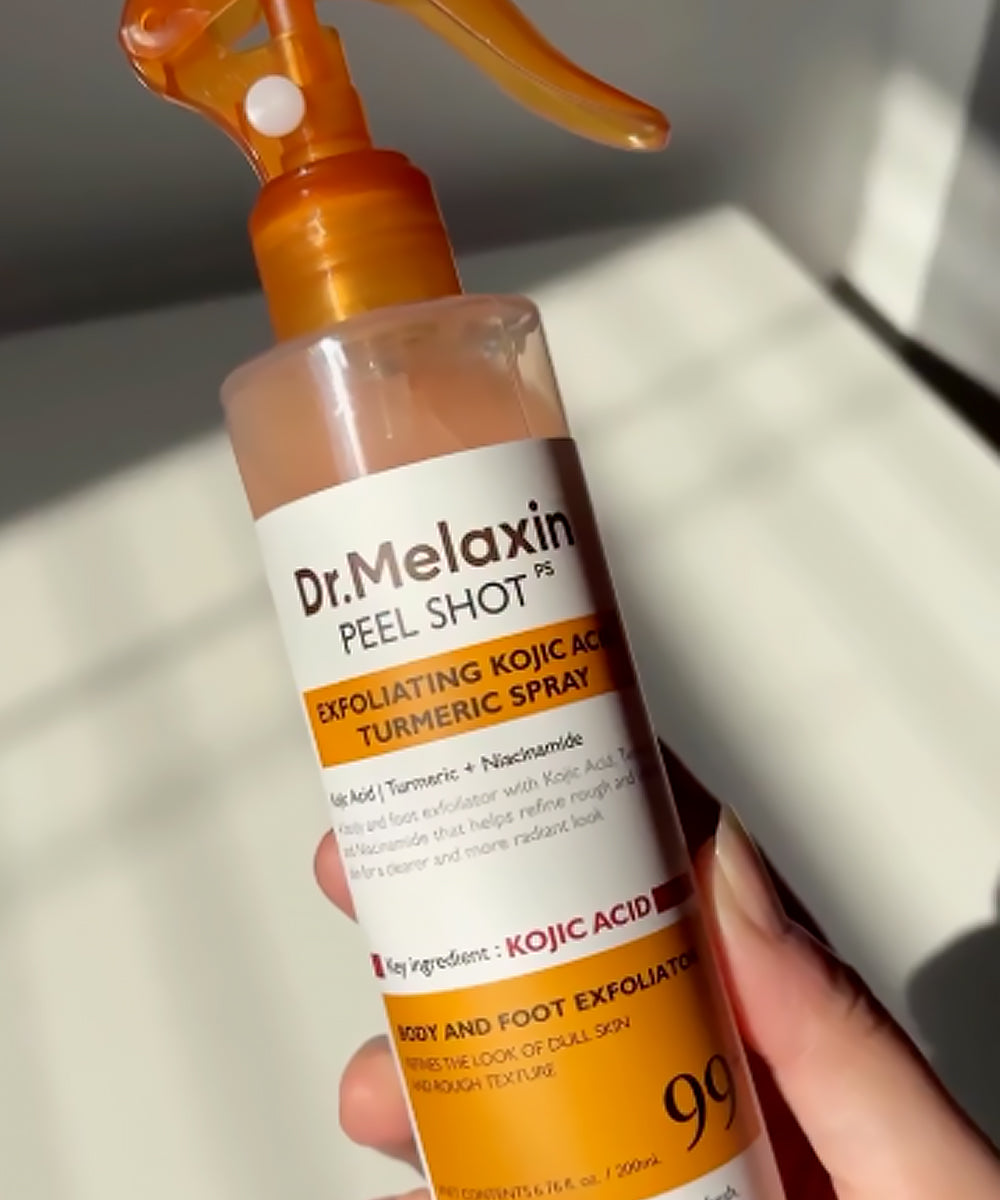 Dr. Melaxin peel shot spray bottle held in a hand with a neutral background