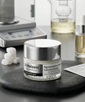 The Dr. Melaxin Calcium Cream jar displayed on a black textured stone within a clinical laboratory setting, emphasizing its scientific formulation