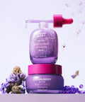 Two purple skincare products with pink caps on a light purple background with flowers.