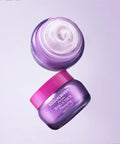 Two jars of skincare cream with visible brand name on a light purple background
