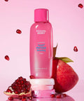 Pink bottle of Equal Berry toner with pomegranate fruits on a pink background
