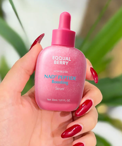 Pink serum bottle with dropper held by a hand against a blurred green leaf background