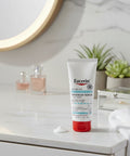 Eucerin Advanced Repair Hand Cream on a bathroom counter with a mirror and plants in the background