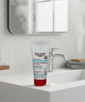 Eucerin Advanced Repair body cream on a bathroom counter with a mirror in the background