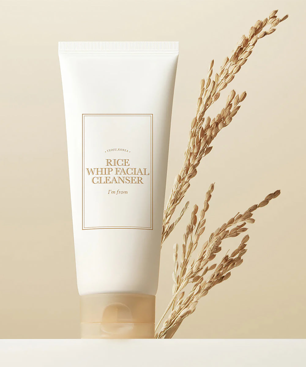 Tube of Rice Whip Facial Cleanser with a branch of rice on a beige background