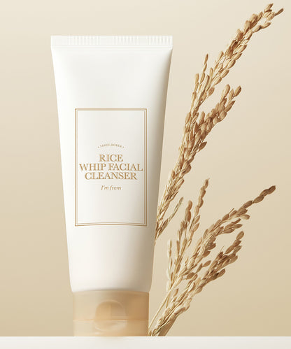 Tube of Rice Whip Facial Cleanser with dried grass on a beige background