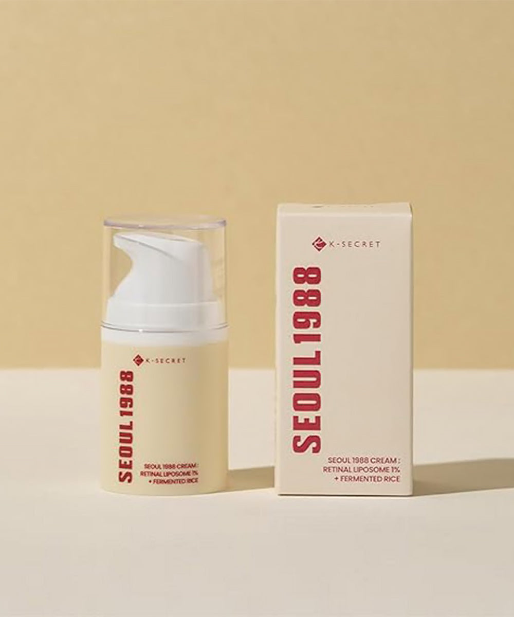Product display photograph showing the K-SECRET Seoul 1988 Cream pump bottle standing next to its branded retail cardboard box on a textured surface against a neutral background