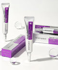 An aesthetic group arrangement of Mary & May Spicule Collagen PDRN Cream tubes and boxes on a white surface with decorative clear spheres and soft lighting