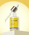 An angled view of the Medicube Deep Vita C Serum bottle with its dropper resting on the rim, positioned on a minimalist light-colored podium