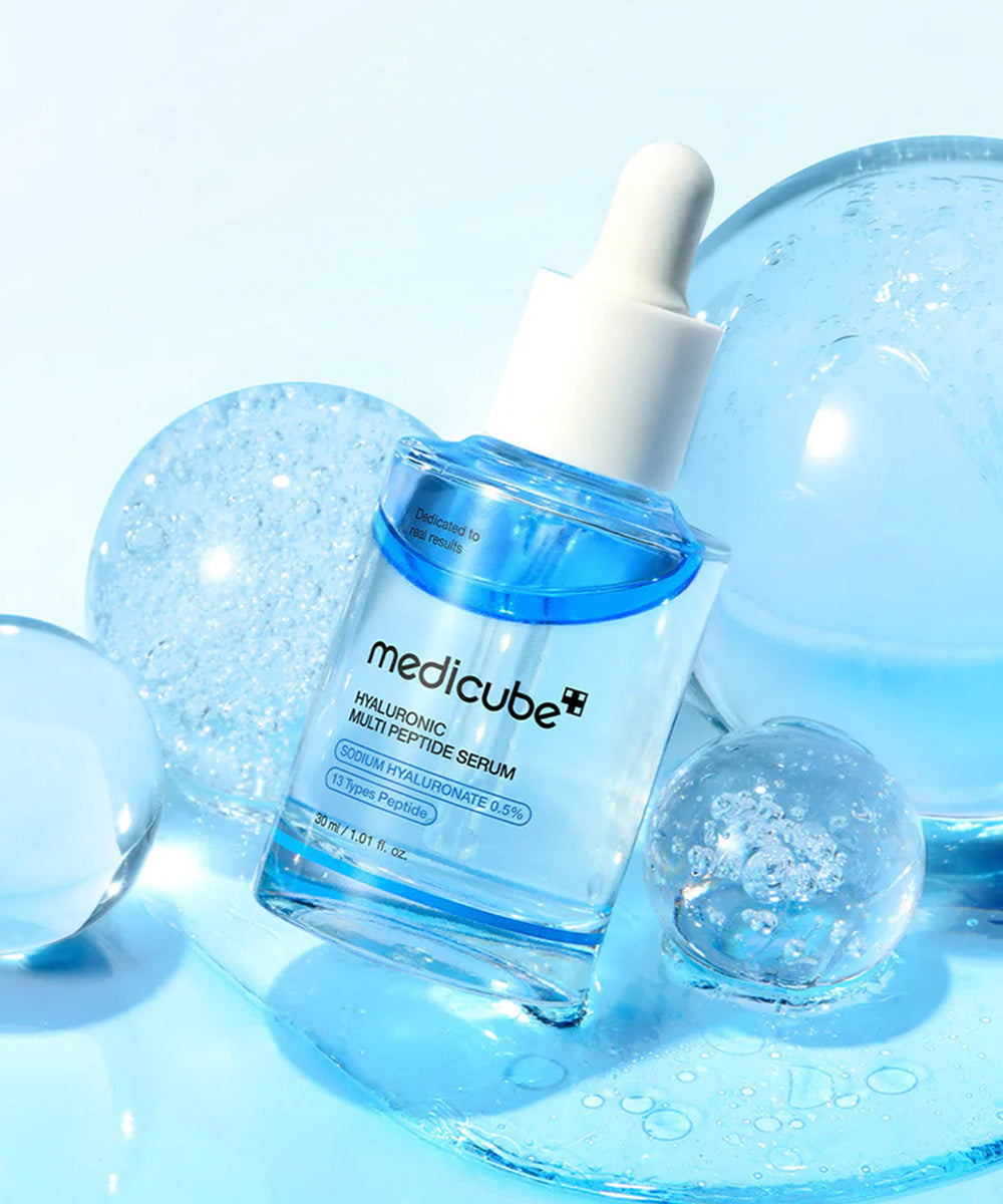 Medicube hyaluronic peptide serum with glossy hydration spheres on blue background