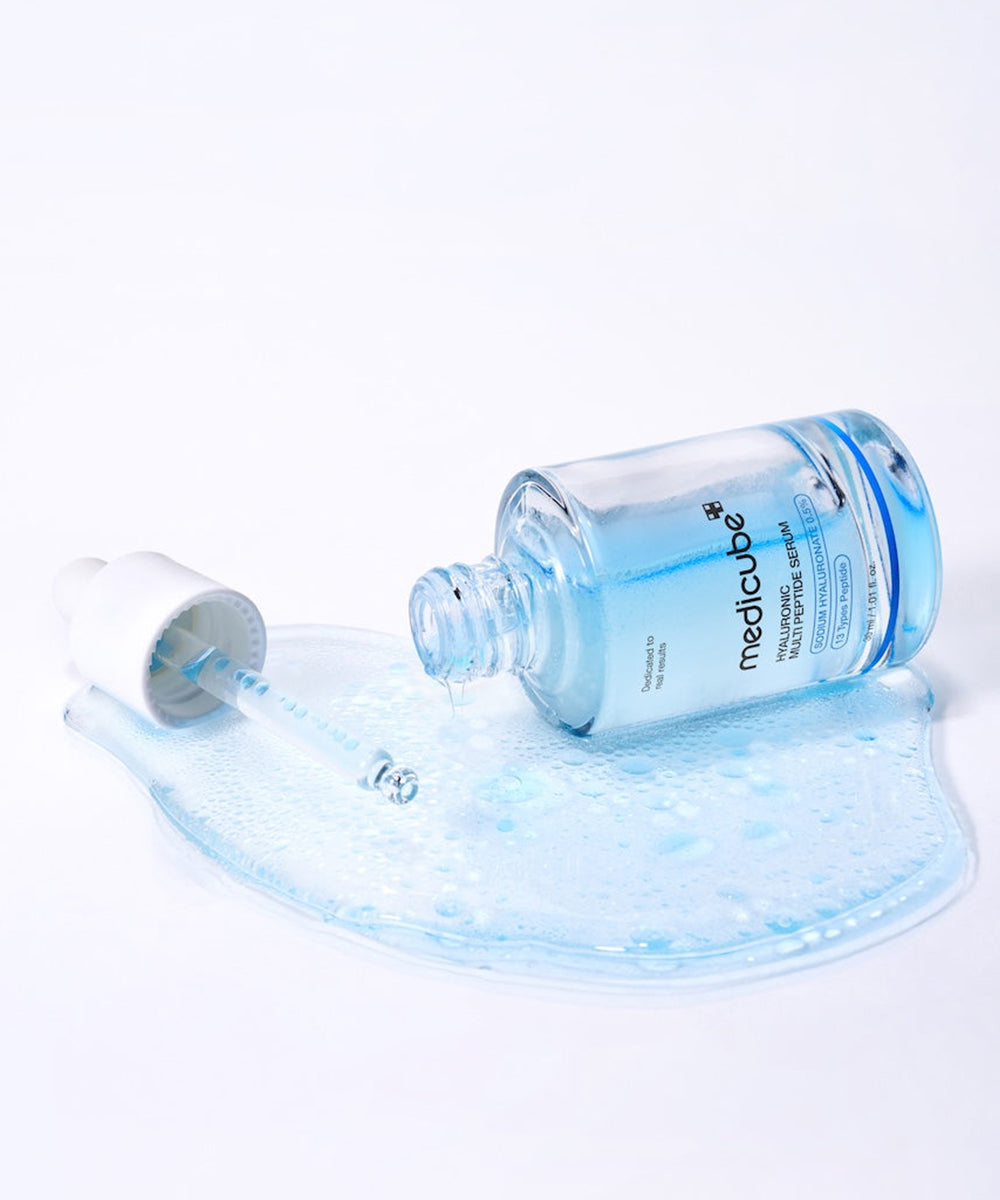 Medicube Hyaluronic Multi Peptide Serum bottle with dropper and spilled serum texture