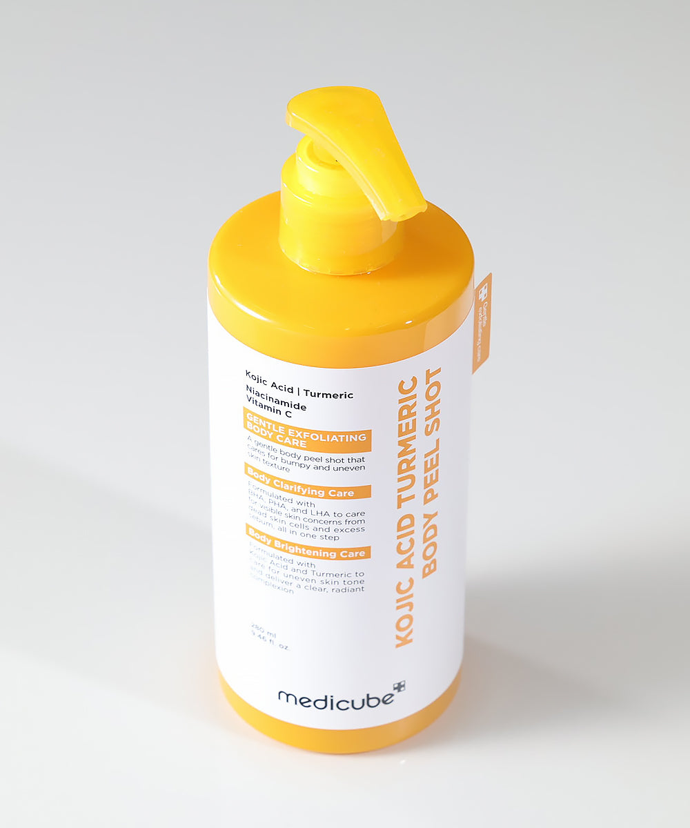The Medicube Kojic Acid Turmeric Body Peel Shot bottle standing next to its clinical white and yellow packaging, reflecting the brand's aesthetic of dermatological science and efficacy