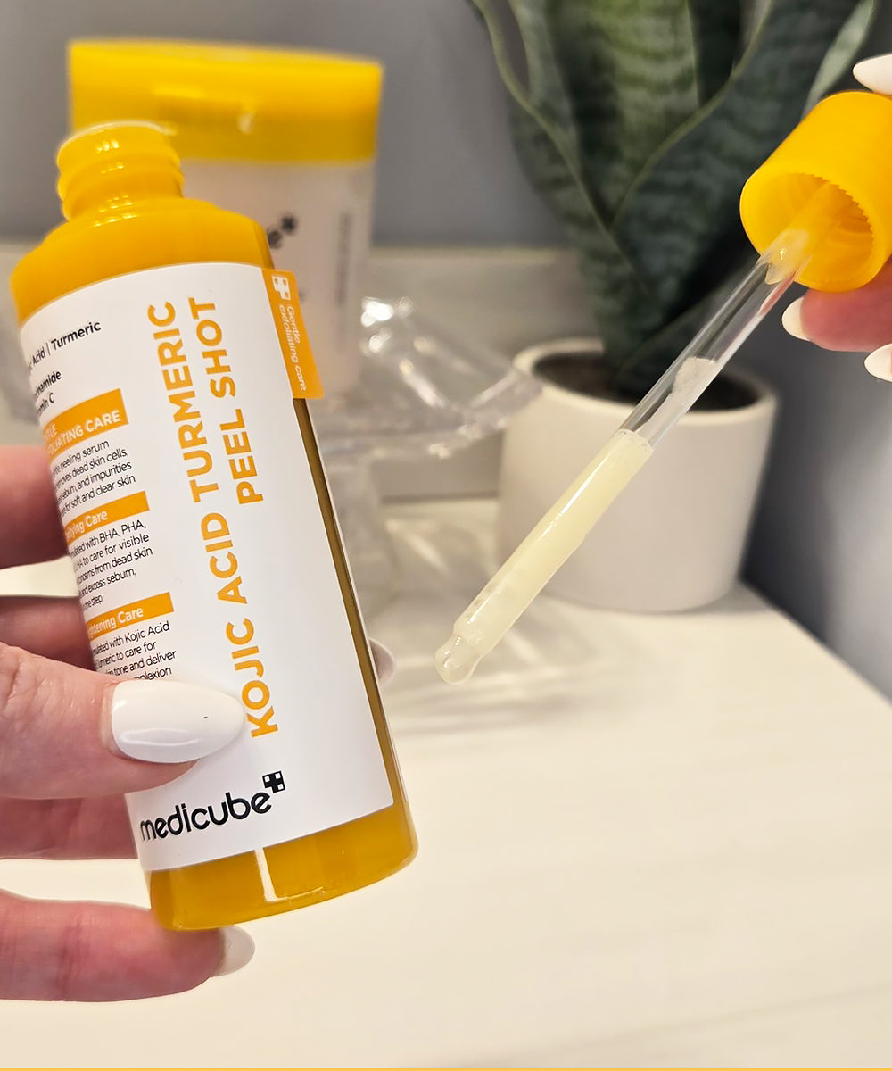 Macro view of a single drop of the yellow turmeric peeling solution, emphasizing the product's clarity and smooth, non-viscous texture for easy absorption