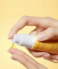 Macro texture shot of the translucent yellow eye gel on a clean surface, emphasizing its smooth consistency and fast-absorbing vitamin-rich formula