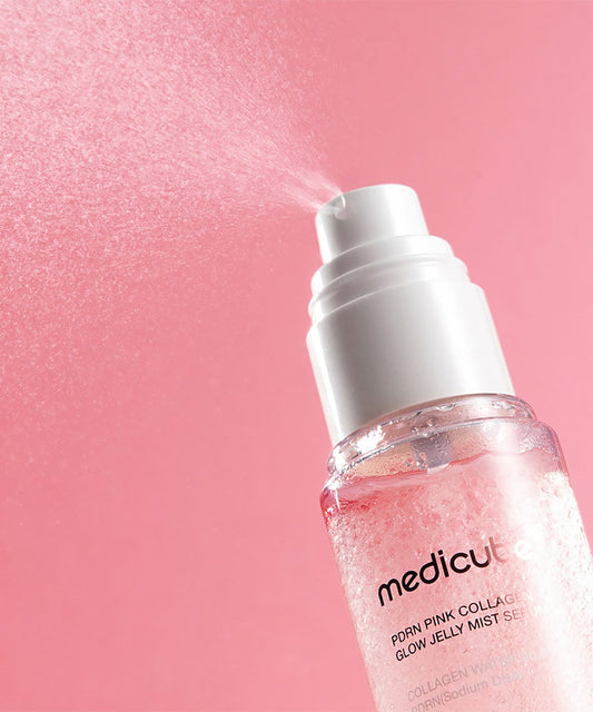 Close-up of the PDRN Pink Collagen Glow Jelly Mist spray nozzle, showing the fine mist being dispensed to highlight the lightweight, glow-enhancing formula