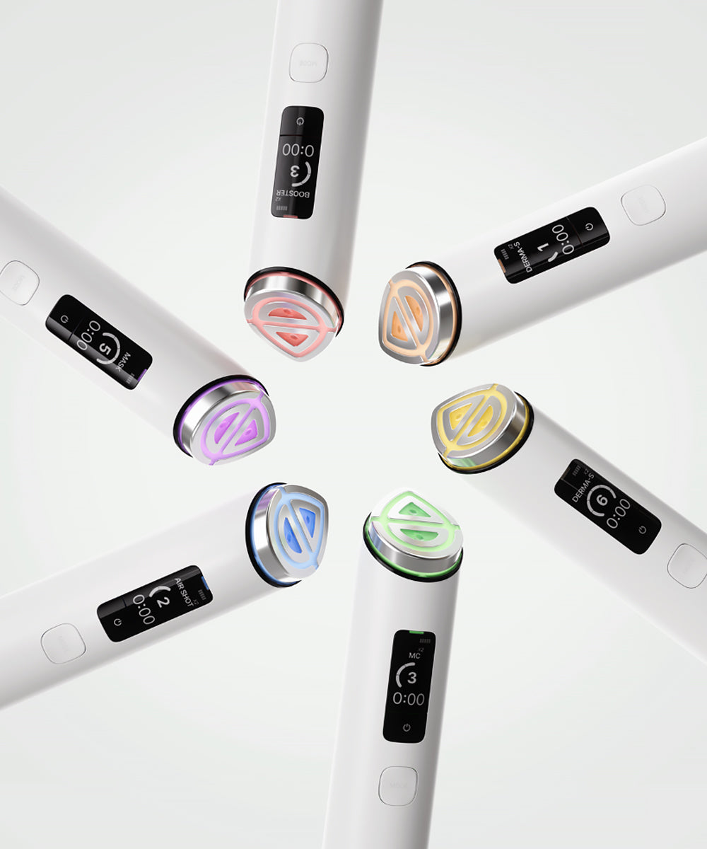 Six handheld beauty devices arranged in a circular pattern on a clean white background. Each device has a white body, a black digital display screen, and a metallic trim accent in different colors: pink, gold, purple, blue, green, and silver.