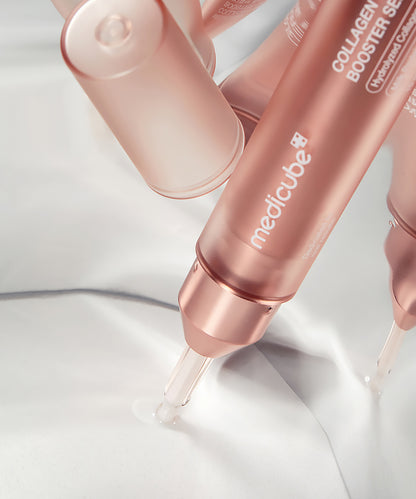 Rose gold skincare serum bottles with 'medicube' branding on a light background
