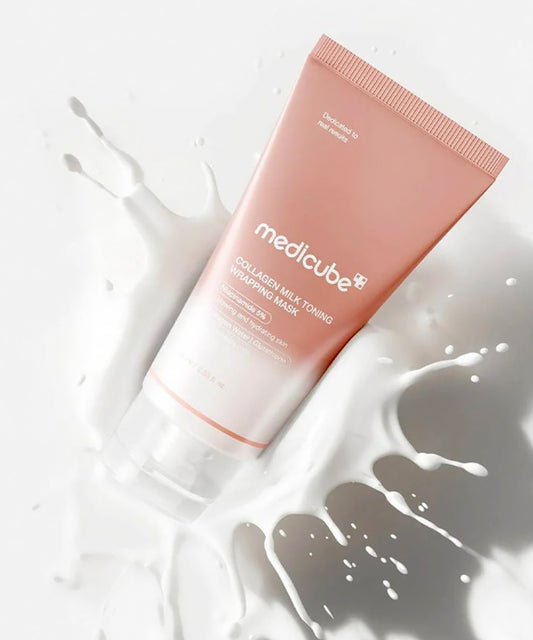 Pink tube of Medicube skincare product on a white background with milk splashes