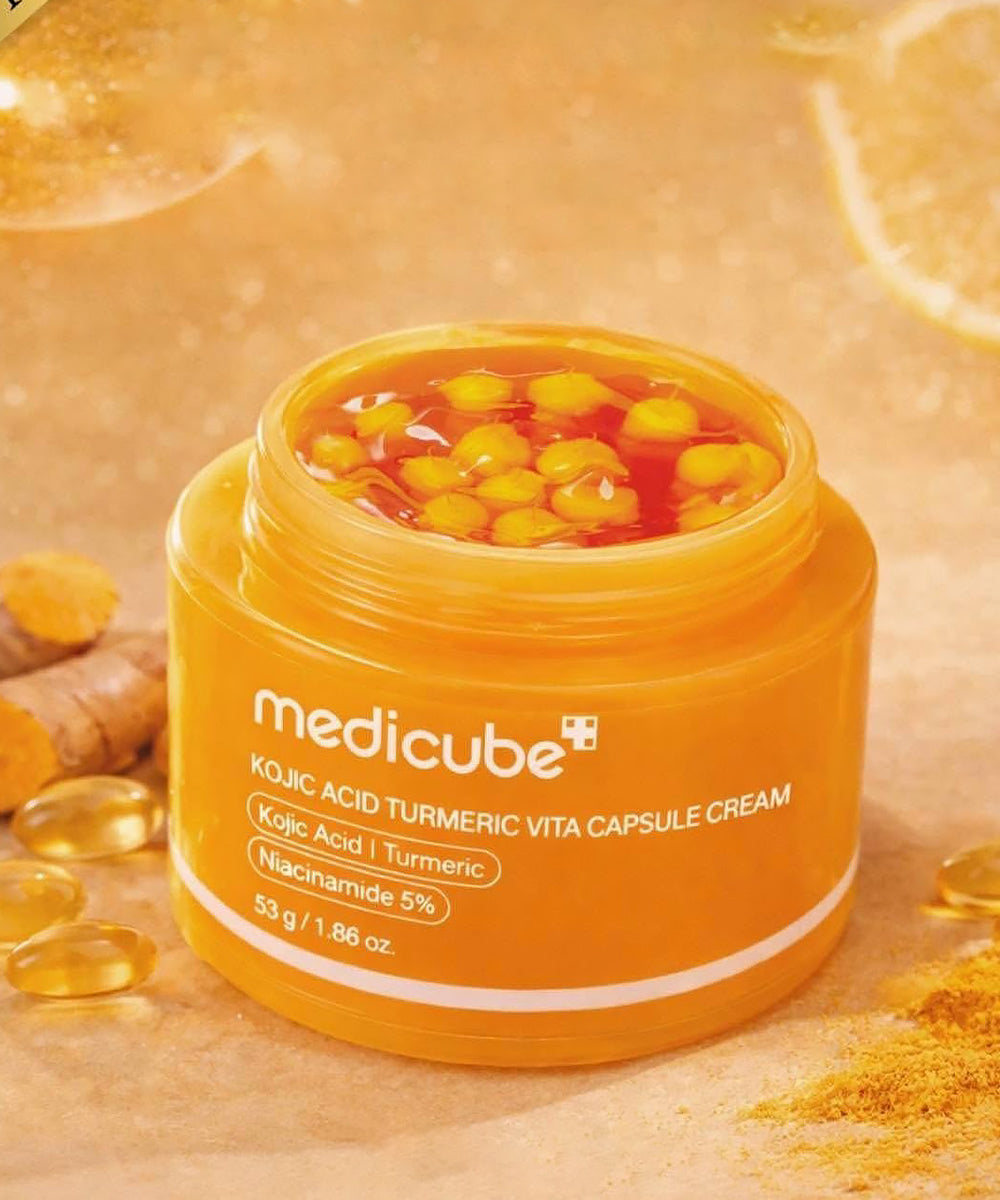 Orange jar of Medicube cream with turmeric capsules on a beige background