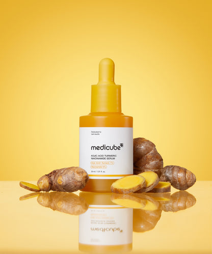 Medicube skincare dropper bottle with turmeric roots on a yellow background