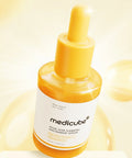 Medicube skincare serum bottle on a light yellow background