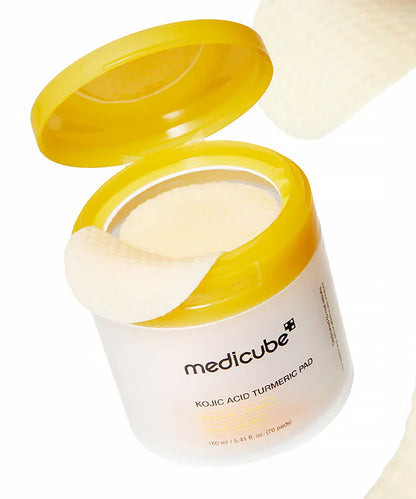 Open jar of Medicube Kojic Acid Turmeric Pad with yellow lid on a white background