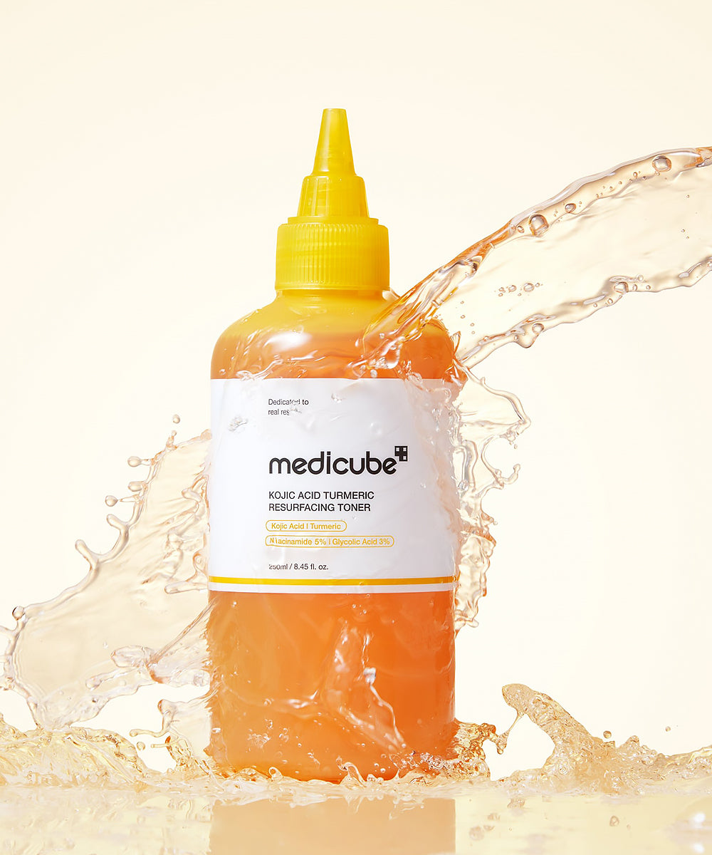 Medicube toner bottle with water splashes on a light background