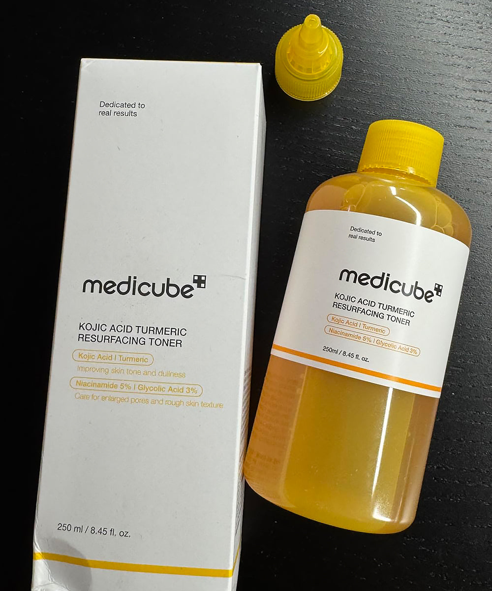 Medicube toner bottle and packaging on a dark surface