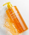 Orange bottle of Medicated Body Wash with water splash on a white background