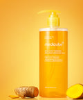 Medicube hair product bottle with turmeric root on a yellow background