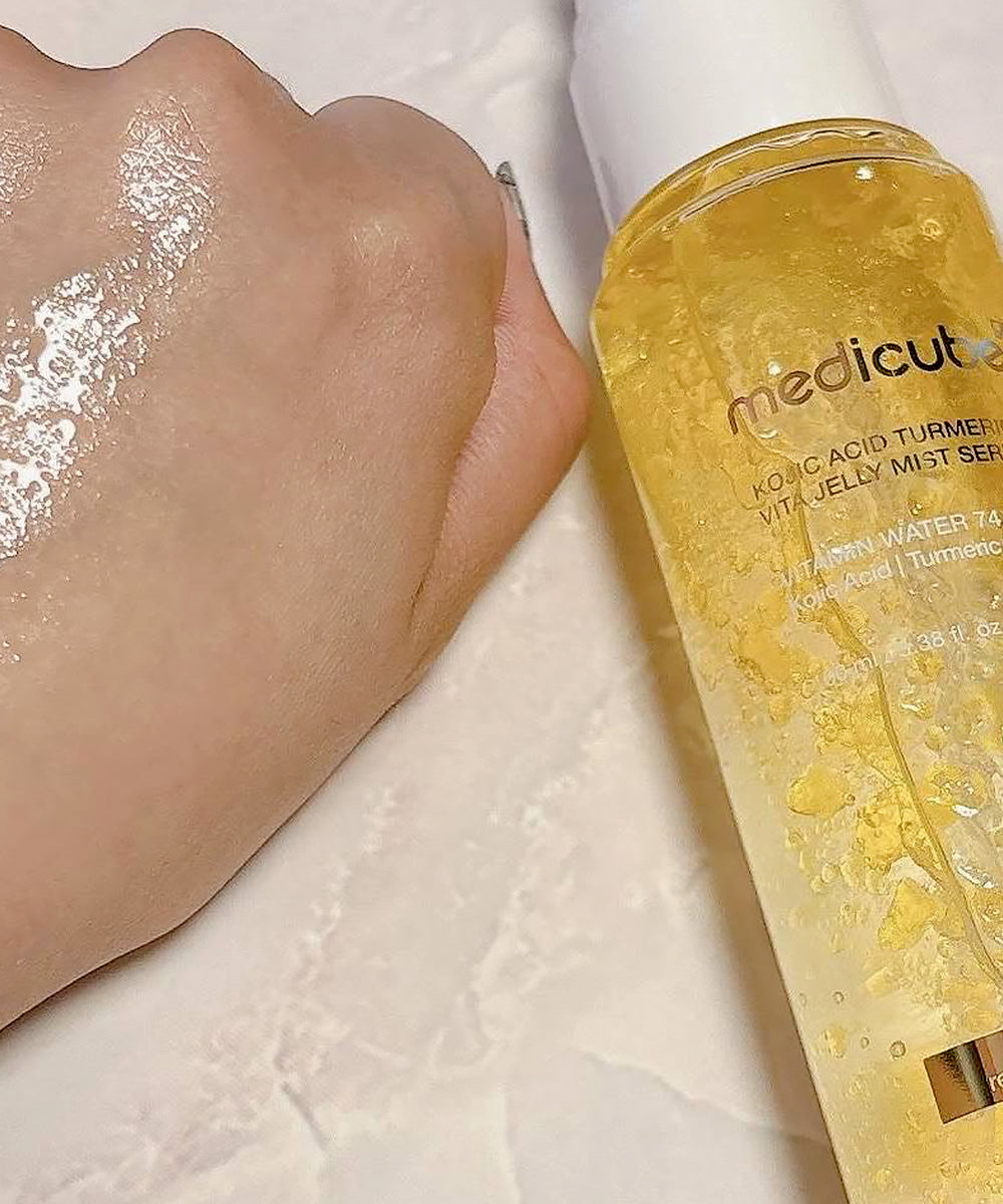 Hand with a visible skincare product application next to a bottle of Medicube skincare serum.