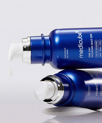 Two blue skincare bottles with white caps on a light gray background