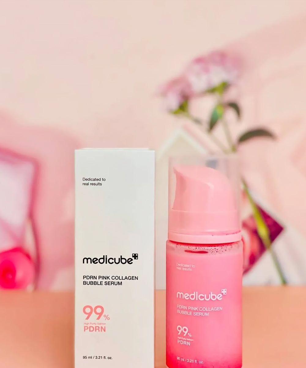 Medicube pink collagen bubble serum bottle and box on a pink background
