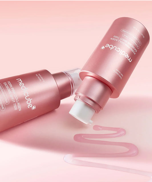 Two bottles of Medicube PDRN Pink Collagen Exosome Shot 7500 shown with a smooth, translucent pink gel serum texture smeared on a soft pink surface