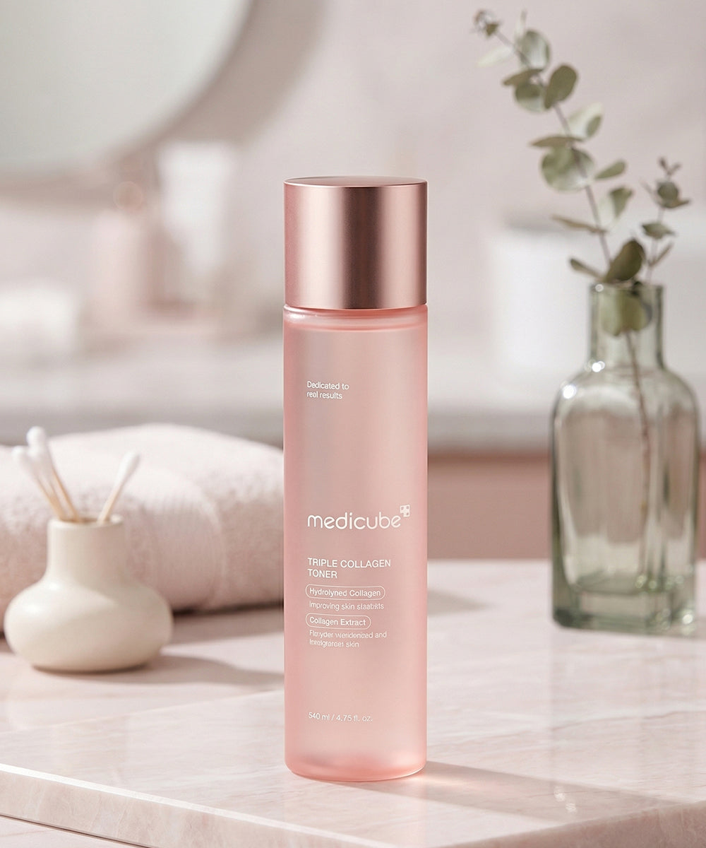 The toner bottle stands on a marble surface in a bright bathroom setting, accompanied by a small vase of eucalyptus and a white towel