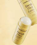 Two Medicube Fresh That Lasts deodorant sticks in a glossy gold packaging, with one upright and one horizontal, on a warm beige background.