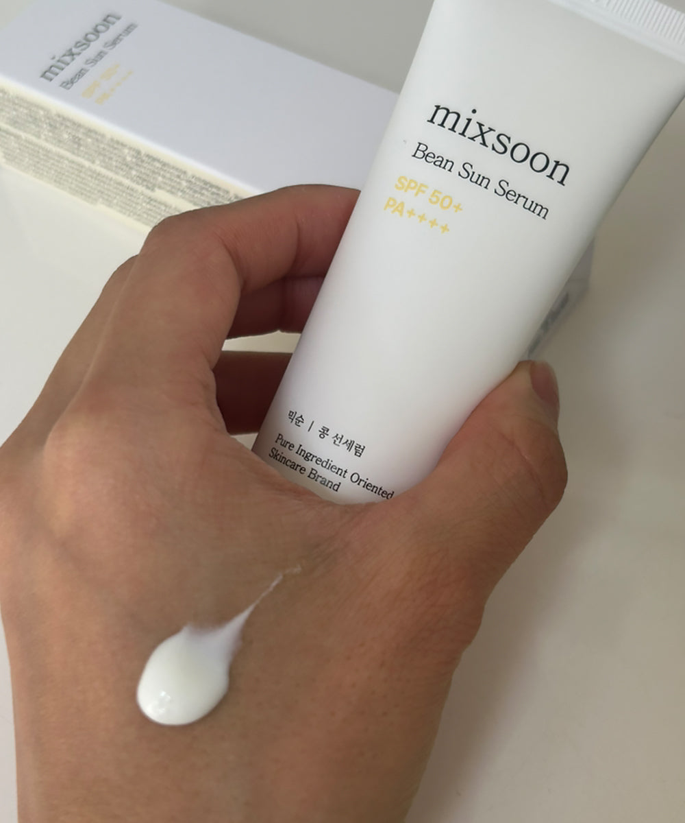 Hand holding a tube of mixsoon Bean Sun Serum with a small amount on the palm.