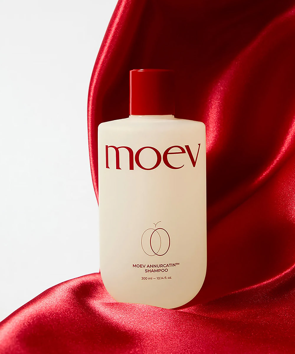 Moev shampoo bottle on a red fabric background